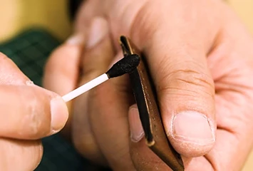Close-up of the leather edge finishing process, demonstrating 4-6 coats of hand-applied oil after professional sanding and polishing for steady performance.