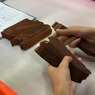 Rigorous batch inspection of cut leather strap components to ensure uniform shape and structural consistency for mass production orders.